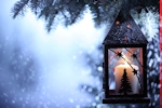 Kerstkaart: Zwarte lantaarn met witte kaars hangt in de kerstboom