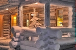 Kerstkaart: Besneeuwde kerstboom op de veranda voor het huis