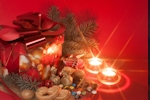 Kerstkaart: Twee waxinelichtjes staan naast een rood kerstcadeau