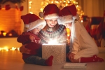 Kerstkaart: Drie kinderen kijken in een pakje waar licht uit komt