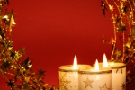 Kerstkaart: Drie brandende witte kaarsen met een rode achtergrond