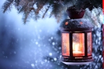 Kerstkaart: Brandende lantaarn in een kerstboom buiten waar het sneeuwt