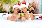 Kerstkaart: Man en vrouw in bad die kerstmutsen dragen