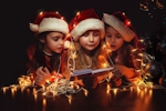 Kerstkaart: Kinderen met rode kerstmutsen en kerstversiering lezen een boek