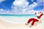 Kerstkaart: De Kerstman zit met een zonnebril op een strandstoel aan zee