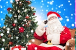Kerstkaart: De Kerstman zit in de stoel naast de kerstboom en voert een gesprek met zijn mobiele telefoon